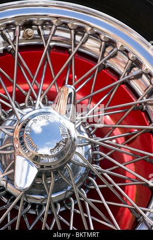 Details of a high chrome wire spare wheel on the back of a Morgan style sports car. Stock Photo