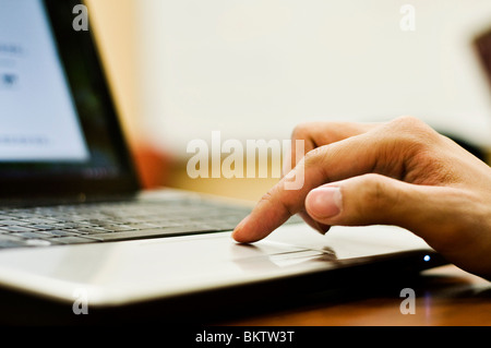 Student's finger on trackpad of wi-fi laptop computer. Stock Photo