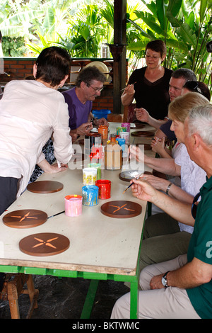 Tourists painting class at factory  making 'carretas',elaborately painted oxcarts in Sarchi,Costa RIca,Mexico Stock Photo
