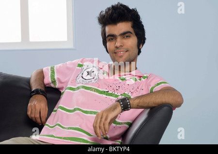 Young man sitting on sofa, portrait Stock Photo