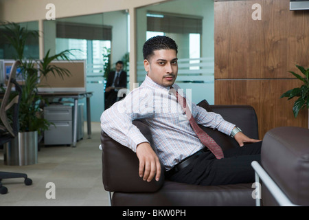Businessman sitting on sofa, portrait Stock Photo