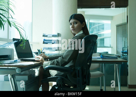 Young woman using laptop, portrait Stock Photo