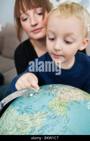 Mother and son looking at globe Stock Photo