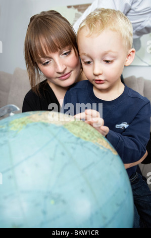 Child pointing at globe Stock Photo