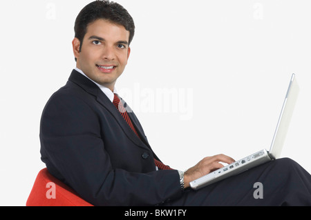 Young man using laptop, portrait Stock Photo