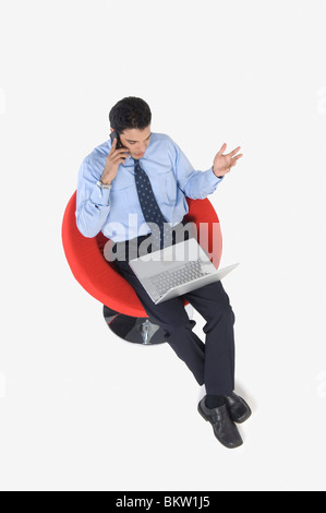 Young businessman using mobile phone, elevated view Stock Photo