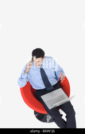 Young businessman using mobile phone, elevated view Stock Photo