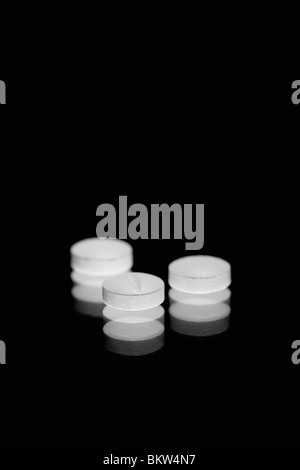 White tablets on a black background