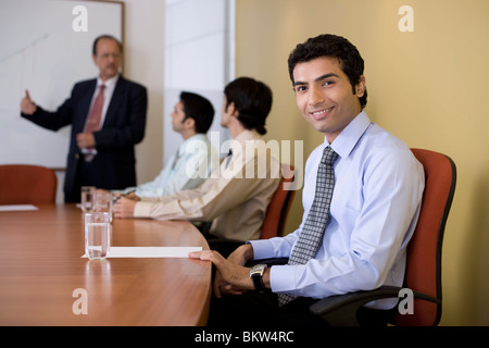 Businessman looking at the camera, background colleagues talking Stock Photo