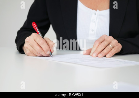 Woman signing paper Stock Photo