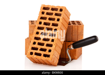 three bricks and a mason's trowel on white background Stock Photo