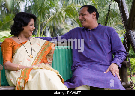 Senior Couple sitting on the swing Stock Photo