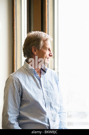 Man looking out through the window Stock Photo