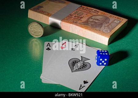 Indian rupee, playing cards and a dice on top a table Stock Photo