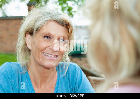 Two female friends sitting outside Stock Photo