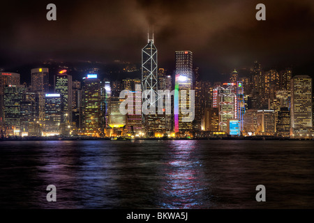 Tall buildings on Hong Kong Island city centre as seen across the harbour from Tsim Sha Tsui on Kowloon side at night Stock Photo