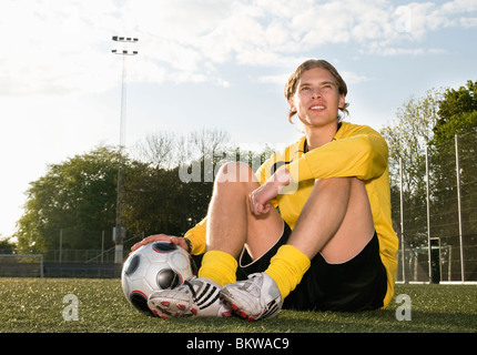 Guy sitting of footballfield Stock Photo