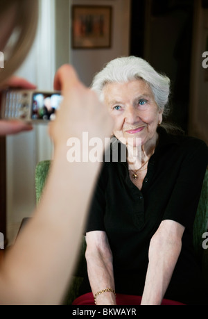 Young woman taking photo of an elderly lady with camera phone Stock Photo