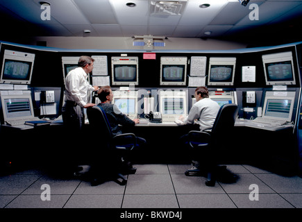 Technicians and engineers working at computers in a telecommunications facility Stock Photo