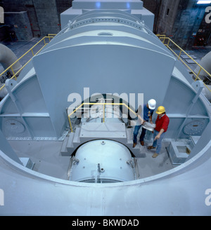Two workers review drawing near a steam turbine at a nuclear power plant in Limerick, Pennsylvania, USA Stock Photo