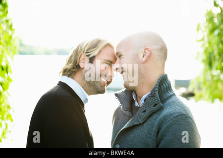 Two smiling gay men by water Stock Photo