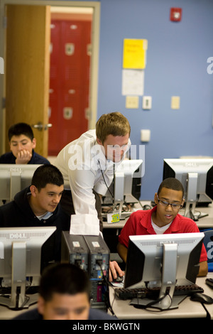 Teacher assists high school students in computer lab at charter school Peak Preparatory Academy in Dallas, Texas, USA. ©Bob Daemmrich Stock Photo