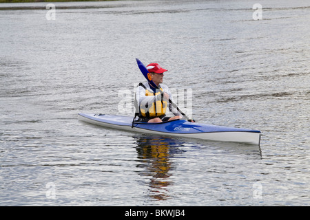 A man wearing a lifejacket paddling a kayak on the Deschutes River, Bend, Oregon. Stock Photo