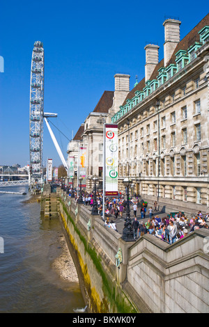 BUSY SCENE ON THE EMBANKMENT LONDON WITH THE MILLENIUM WHEEL AND COUNTY HALL WHICH IS NOW A MARRIOT HOTEL Stock Photo