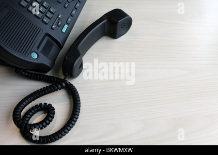 Part of a business telephone with the receiver off the hook Stock Photo