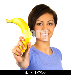 A young woman holds up a banana Stock Photo