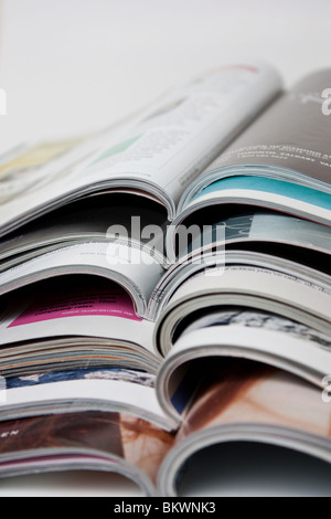 opened magazines on a pile magazine women spread pile magazines vogue fashion Stock Photo