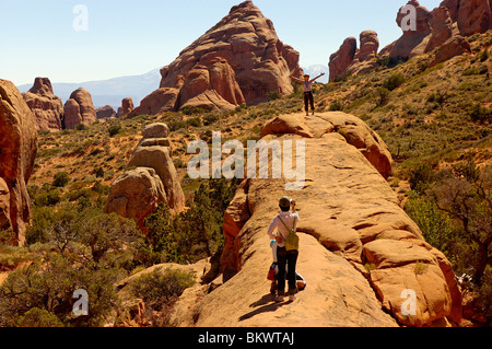 Stock photograph of Japanese tourists posing for pictures in Devils Garden, Arches National Park,  Utah, USA. Stock Photo