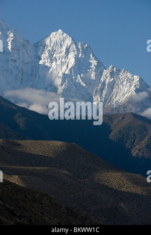 Snow capped mountain above desert hills, Nilgiri North, Kagbeni, Annapurna Circuit, Mustang District, Nepal, Stock Photo