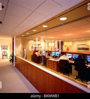 Corporate workers at desks using computers & telephones in the offices of an asset management company Stock Photo