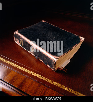 Still life study of a Holy Bible on an antique leather top desk Stock Photo