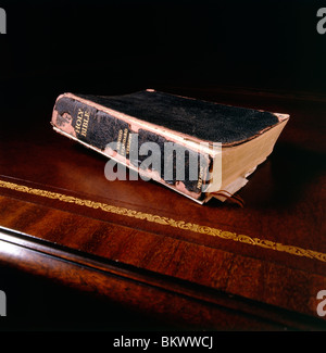 Still life study of a Holy Bible on an antique leather top desk Stock Photo