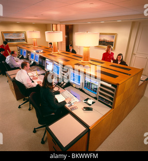 Corporate workers at desks using computers & telephones in the offices of an asset management company Stock Photo