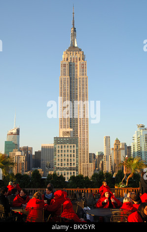 Roof-top terrace bar with view at the State Empire Building overtops all other high-rise buildings in Manhattan, New York, USA Stock Photo