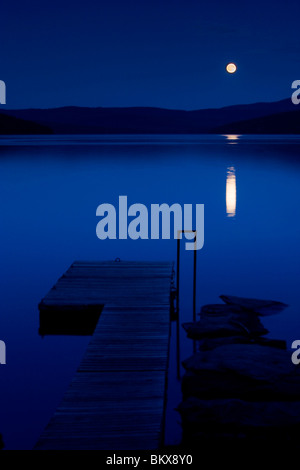 A full moon rises over Lake Francis in Pittsburg, New Hampshire. Stock Photo