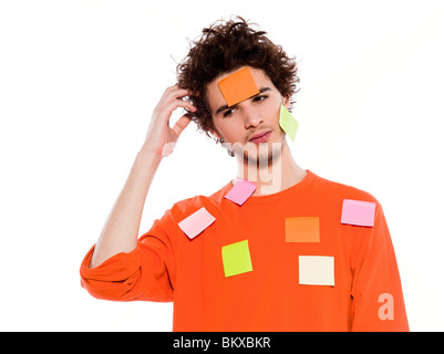 one young thinking with adhesive notes covering caucasian man portrait in studio on isolated white background Stock Photo