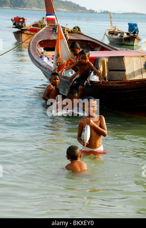 young boy with fresh fish in the sea ,chao leh, sea gypsy village , rawai beach , phuket island ,thailand Stock Photo