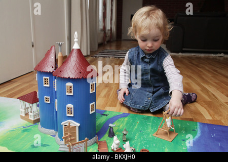 NORDIC TODDLER WITh MOOMIN CASTLE: A two year old baby girl toddler child playing with toy doll model house moomin moomins model released Stock Photo