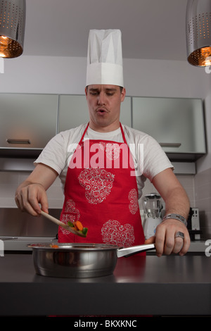 Cook singing and cooking in the kitchen. Stock Photo