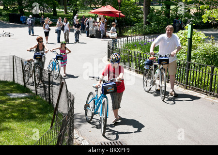 father mother & pre teen son & daughter set out for a family bike ride in Central Park New York City Stock Photo