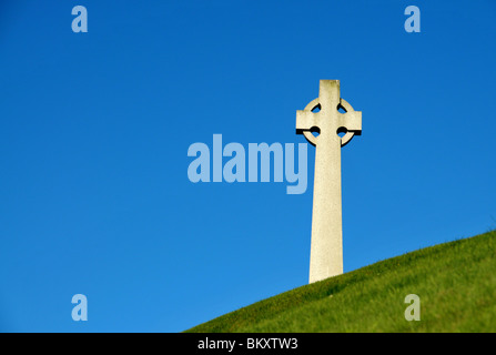 A stone Celtic  cross war memorial standing on a grassy mound  - north east of Scotland. Stock Photo