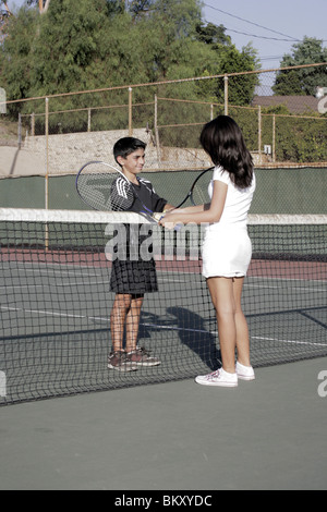 Two children shaking hands after playing tennis Stock Photo