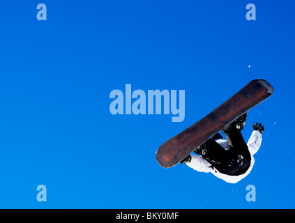 Person in midair jumping while snowboarding Stock Photo