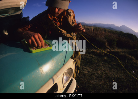 A man picks a fly from his fly box while  fishing in Bishop, California. Stock Photo