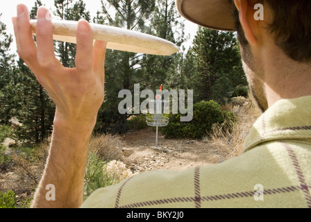 A young man perfects the pizza toss during a game of disc golf in Lake Tahoe, California. Stock Photo