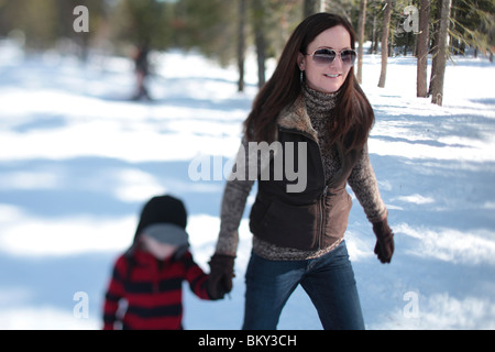 A mother snowshoes with her 4 year-old son in the snow covered wilderness of Lake Tahoe, Calfornia. Stock Photo